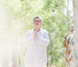 Woman standing in prayer pose with light on left side